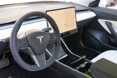 interior of Tesla EV showing steering wheel and center console