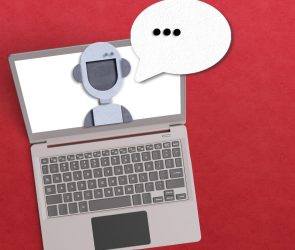 AI agent concept with robot inside a laptop with a voice bubble on red background.