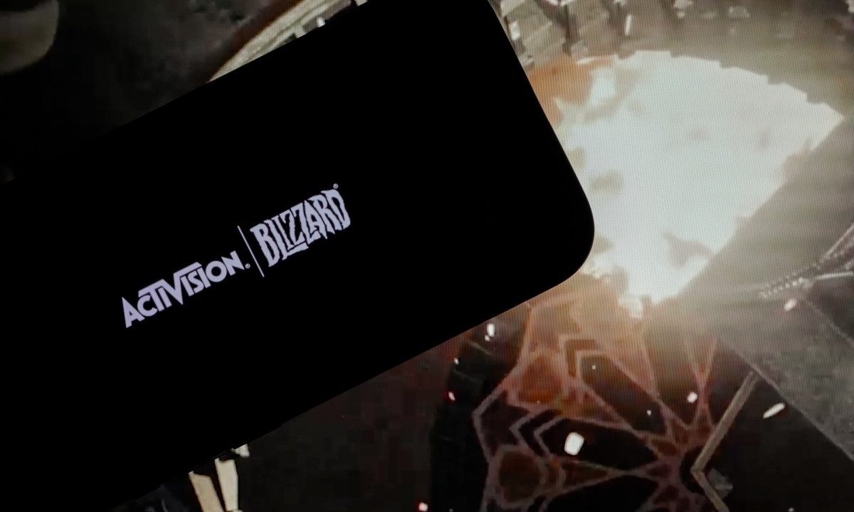 logo of ''Activision Blizzard'' is displayed on a mobile phone screen in front of a computer