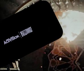 logo of ''Activision Blizzard'' is displayed on a mobile phone screen in front of a computer