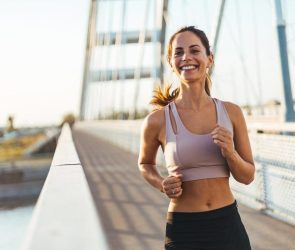 Happy Active Woman Jogging on Bridge Running