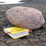 Pink Granite Boulder Next to a Yellow Notebook
