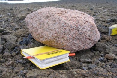 Pink Granite Boulder Next to a Yellow Notebook