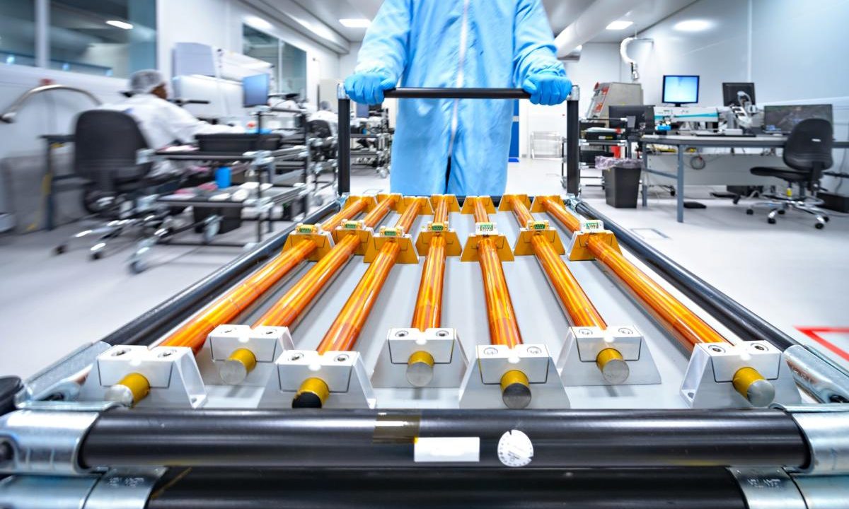 Copper rods being moved on a cart.