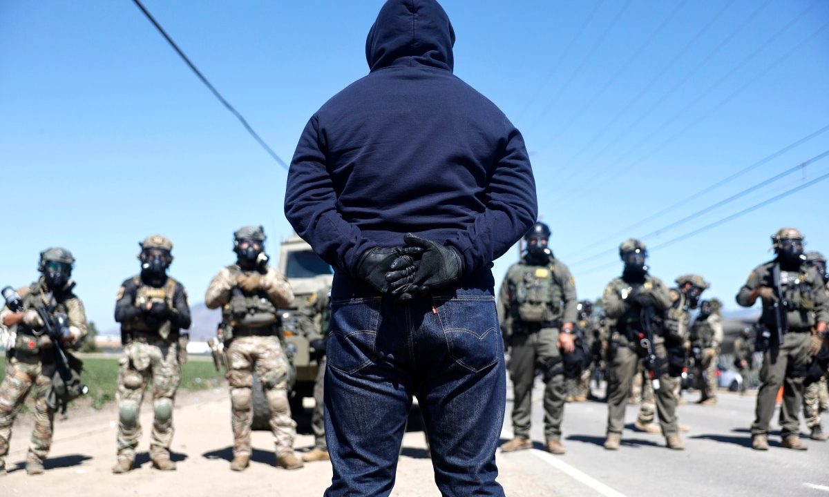 Federal agents block people protesting an ICE immigration raid at a nearby licensed cannabis farm on July 10, 2025 near Camarillo, California.