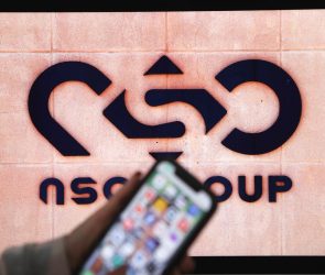 A photographic illustration shows a mobile phone near the NSO Group company logo on February 9, 2022 in the Israeli city of Netanya.