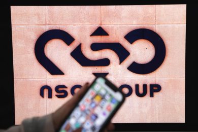 A photographic illustration shows a mobile phone near the NSO Group company logo on February 9, 2022 in the Israeli city of Netanya.