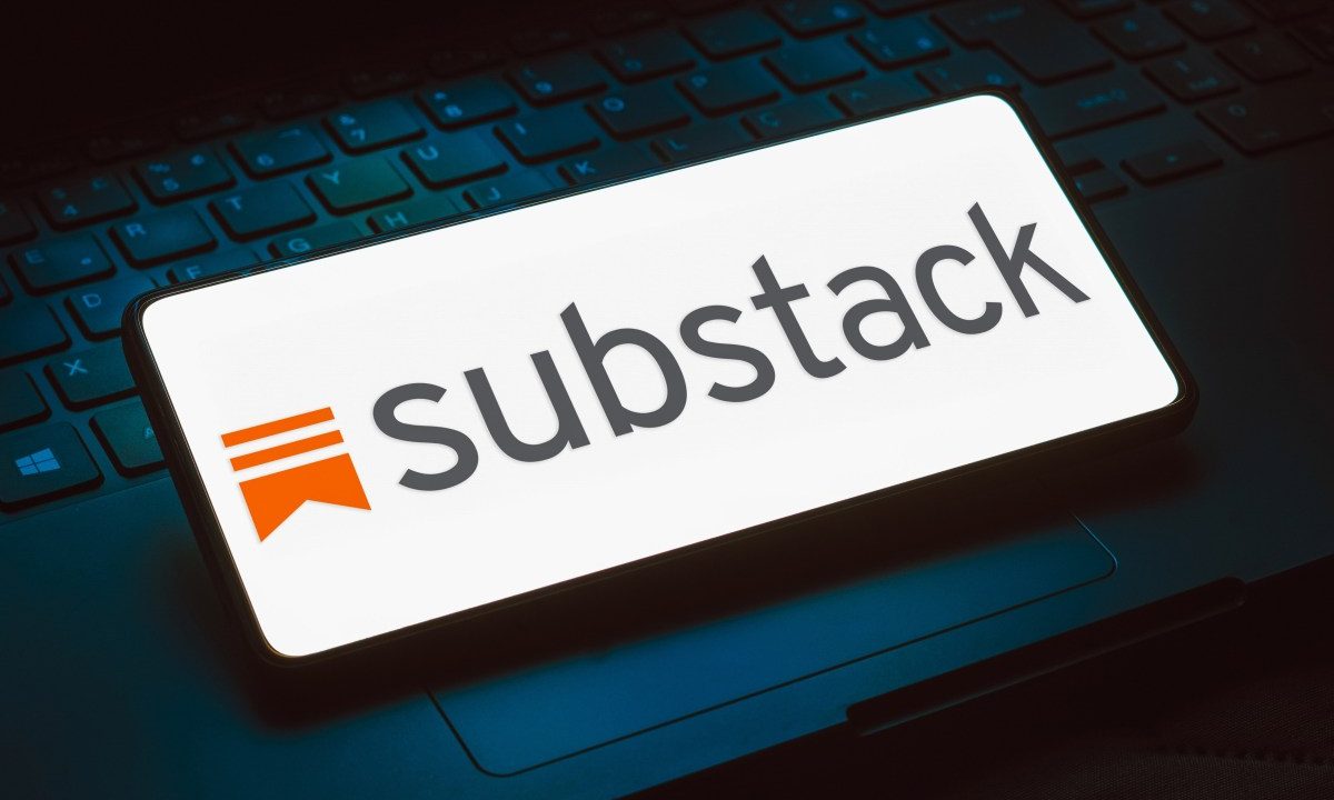 The Substack logo displayed on a phone that is resting on top of a keyboard
