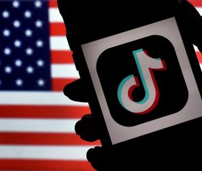 In this photo illustration, the social media application logo, TikTok is displayed on the screen of an iPhone on an American flag background on August 3, 2020 in Arlington, Virginia. - The US Senate voted on August 6, 2020, to bar TikTok from being downloaded onto US government employees' telephones, intensifying US scrutiny of the popular Chinese-owned video app. The bill passed by the Republican controlled Senate now goes to the House of Representatives, led by Democrats. (Photo by Olivier DOULIERY / AFP) (Photo by OLIVIER DOULIERY/AFP via Getty Images)