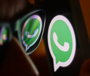 WhatsApp logo reflected on sunglasses and displayed on a phone screen.