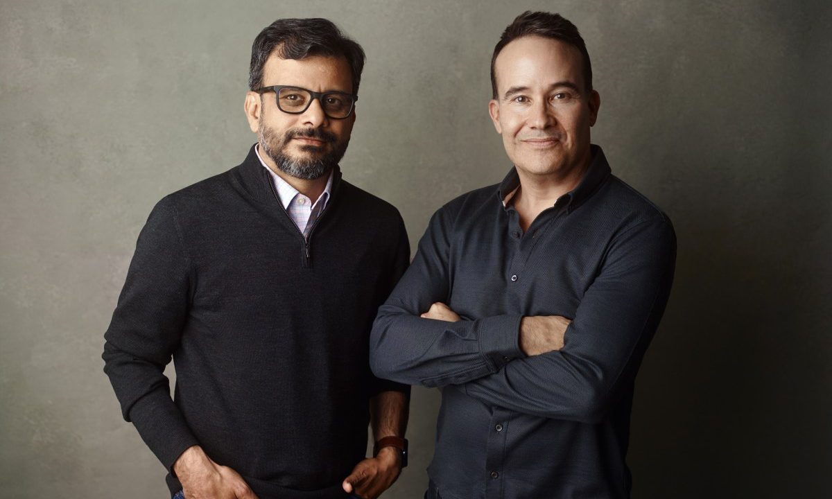 a picture showing the co-founders of Kana, Tom Chavez and Vivek Vaidya, leaning against a grey background