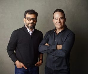 a picture showing the co-founders of Kana, Tom Chavez and Vivek Vaidya, leaning against a grey background