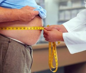 Doctor Measuring Waist Obese Man