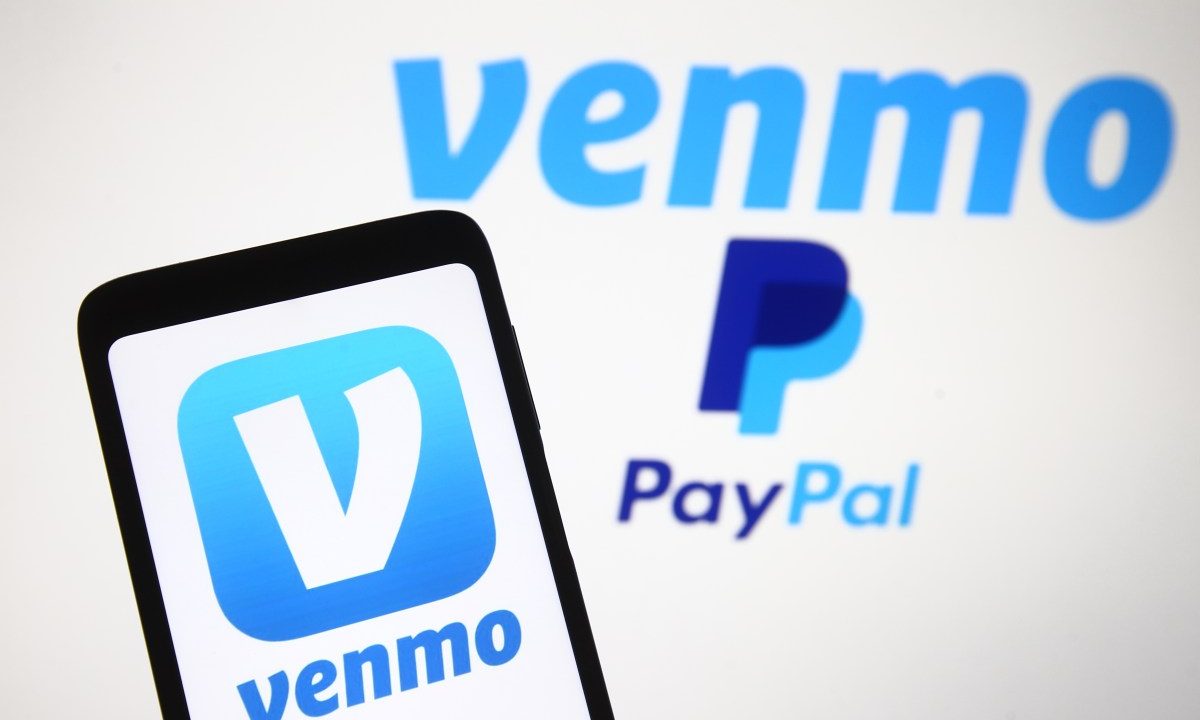 Venmo logo, a mobile payment service of PayPal is seen displayed on a smartphone and a PC screen.