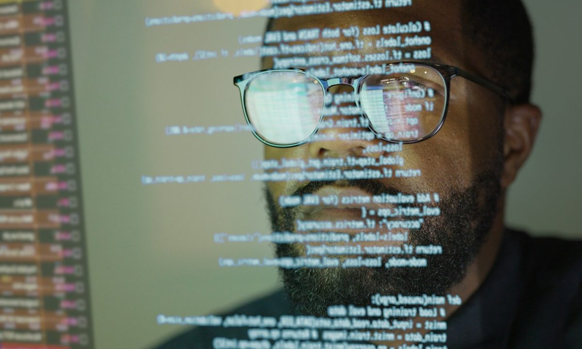 Man studying a see-through display depicting Python computer coding.