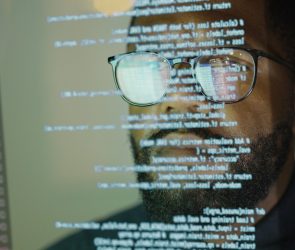 Man studying a see-through display depicting Python computer coding.