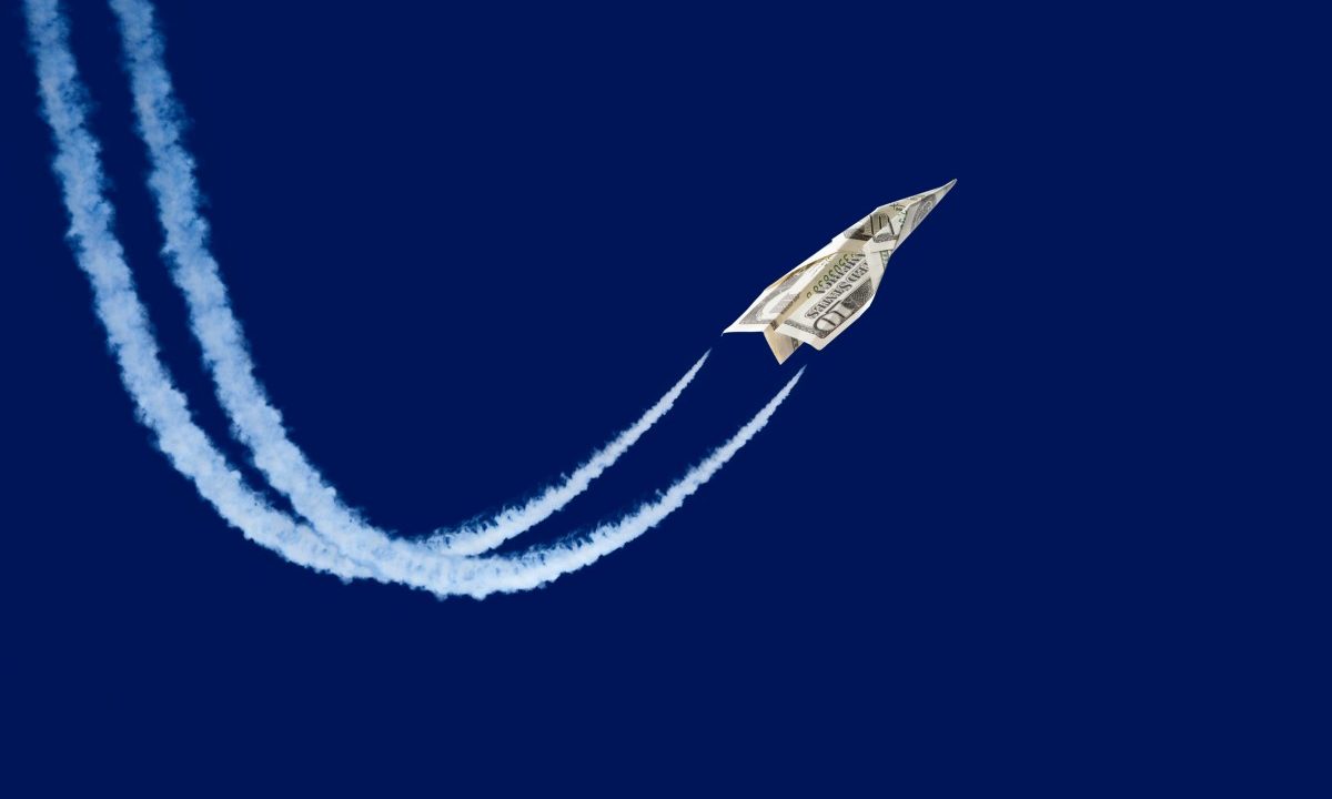 Dollar shaped paper airplane flying up