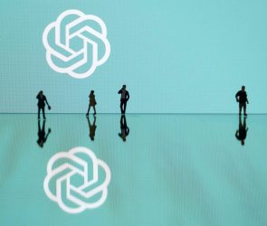 This photograph taken in Mulhouse, eastern France on October 19, 2023, shows figurines next to the ChatGPT logo. (Photo by SEBASTIEN BOZON/AFP via Getty Images)