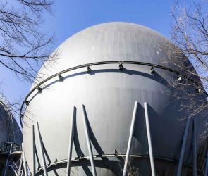 Industrial hydrogen storage tank stands against a blue sky.