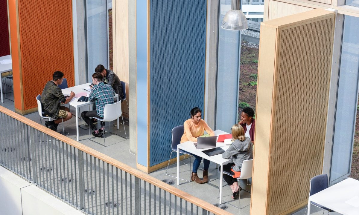Groups of college students sitting in booths, discussing