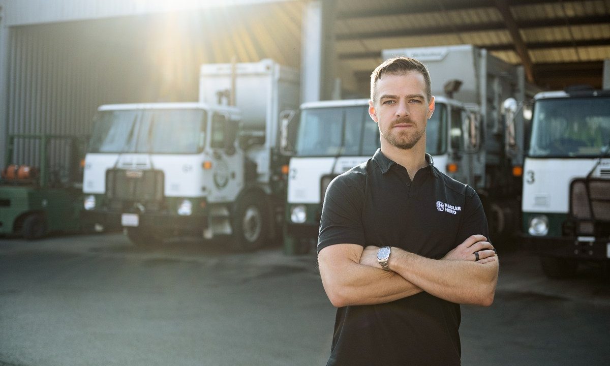 Image of Mark Hoadley, Hauler Hero co-founder and CEO, in front of garbage trucks.