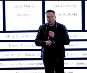 Elon Musk stands in front of xAI's new org chart