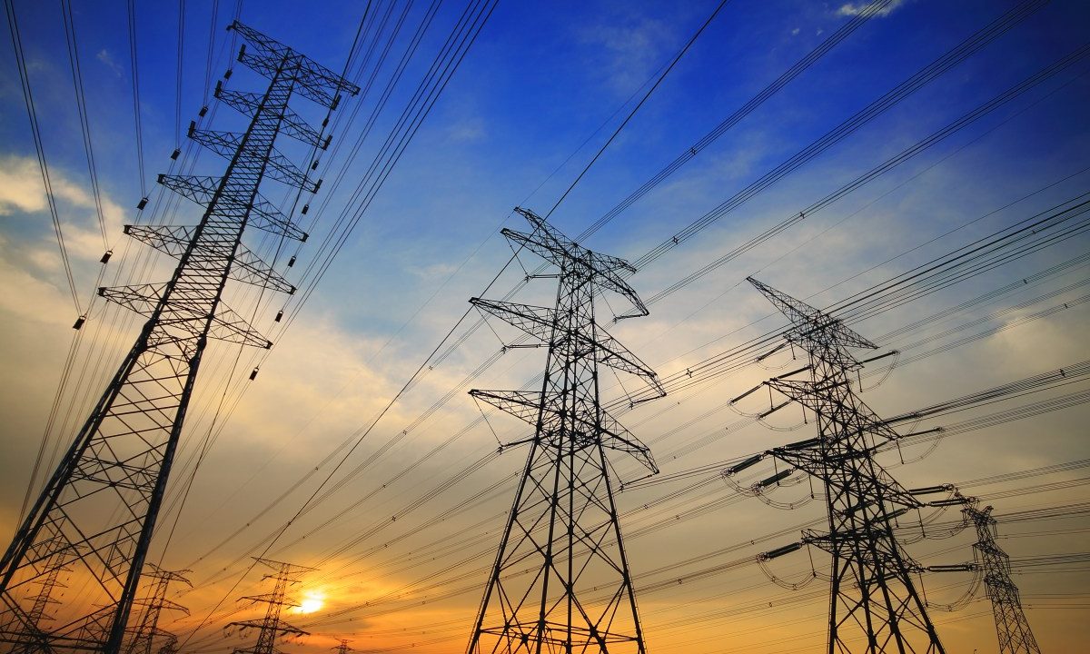 High tension power lines against a sunset