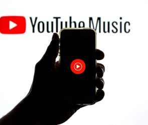 The YouTube Music app seen displayed on a smartphone screen and a YouTube Music logo in the background.
