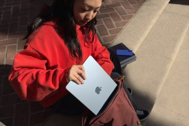 young woman putting Apple MacBook Air into a satchel