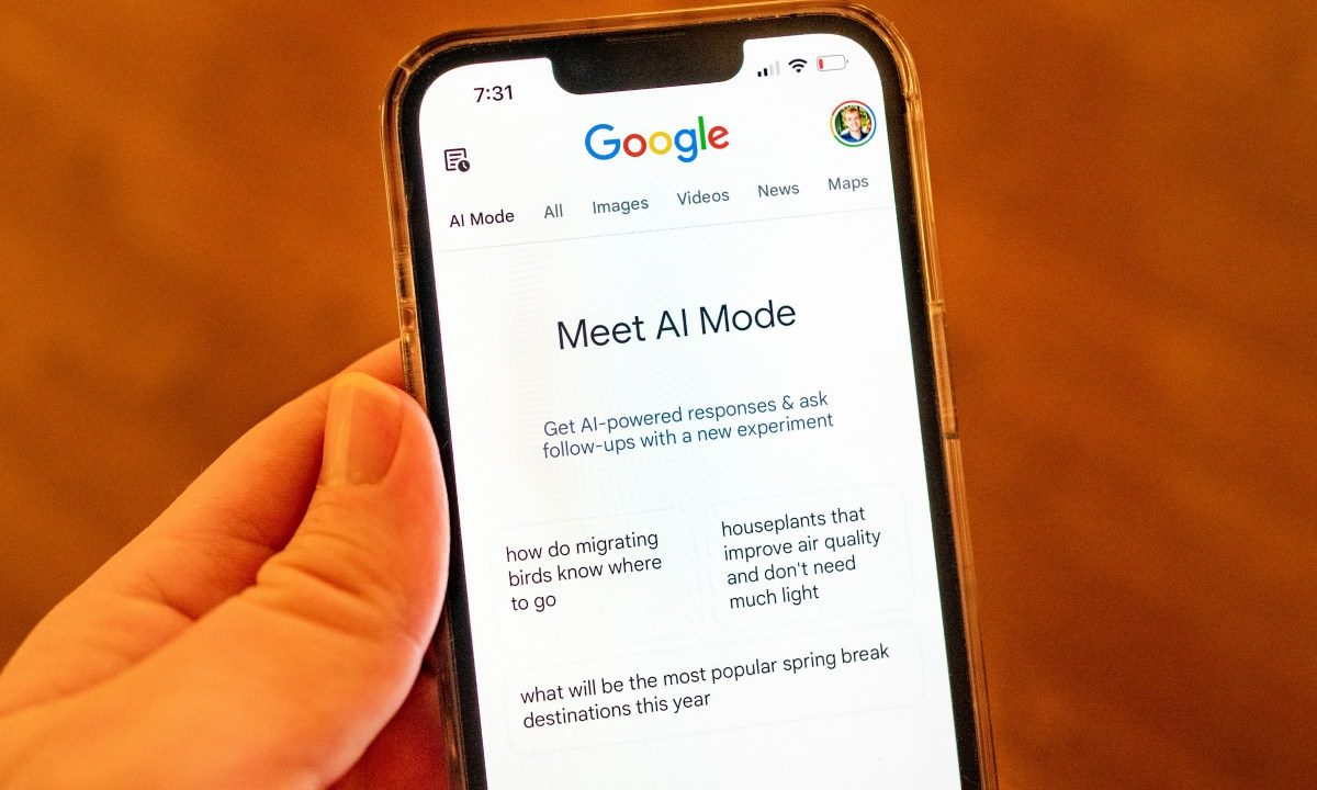 A person holding an iPhone and using Google AI Mode