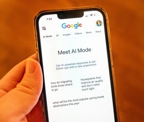 A person holding an iPhone and using Google AI Mode