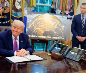 Golden Dome missile program placard with Trump sitting at desk