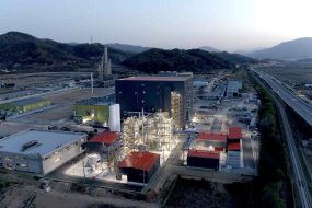 A battery materials factory is lit up at dusk.