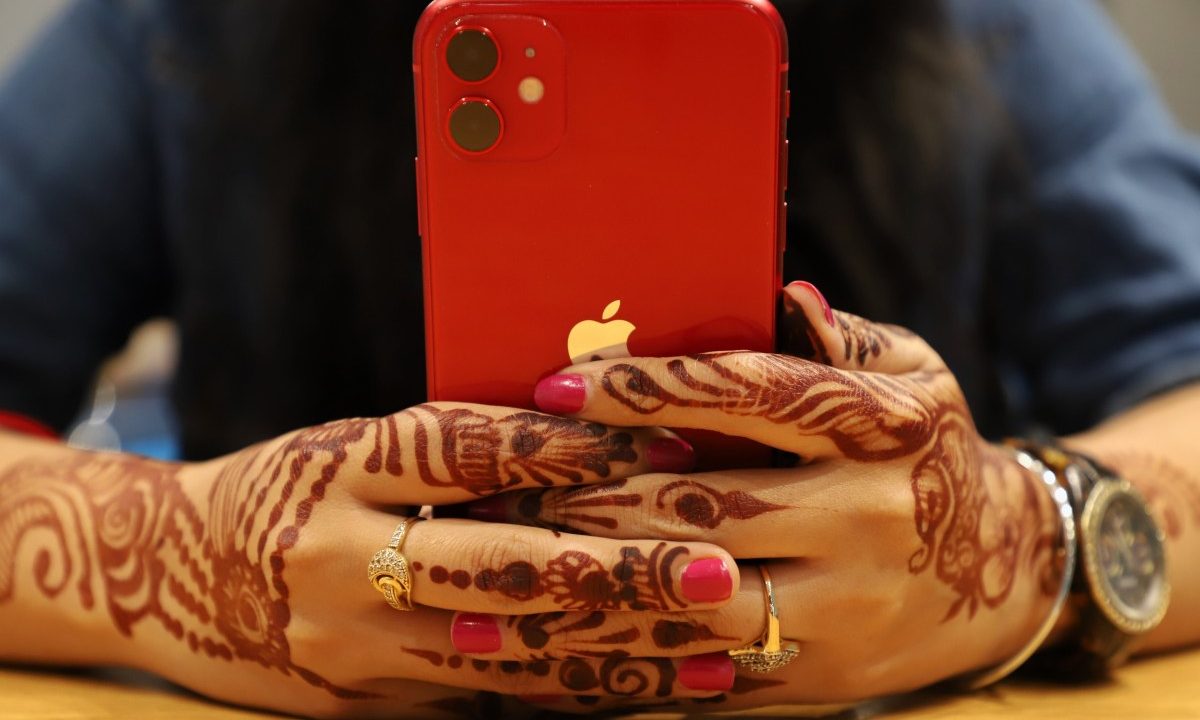 red iPhone held in two hands