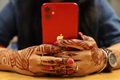 red iPhone held in two hands